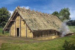 Rekonstrukce obytného domu  prvních zemědělců střední Evropy,  lidu kultury s lineární keramikou.  Kůlová konstrukce je na stěnách  vypletena proutím a omazaná hlínou, sedlová střecha je ze slámy. Foto A. Czekaj-Zastawny (2008, Fig. 33), s laskavým svolením autorky