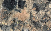 Úlomky dřevěného uhlí se vyskytují jak v klastických sedimentech (na obr.), tak v uhelných slojích. Klasty dřevěného uhlí na vrstevní ploše jílovitého prachovce uloženého na nivě křídové řeky  (stupně coniak/santon, zhruba před  85 miliony let), vrt Dunajovice u Třeboně. Délka zobrazené části vzorku  přibližně 6 cm. Foto S. Opluštil